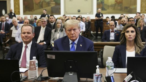 Former US president Donald Trump sits with his attorneys during the opening day of a civil fraud case brought by New York Attorney General Letitia James