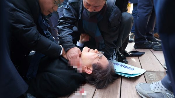 South Korean opposition party leader Lee Jae-myung is attended to after being stabbed in Busan on Tuesday