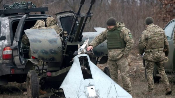 A Ukrainian Air Defence serviceman looks at pieces of a destroyed attack drone near Kyiv